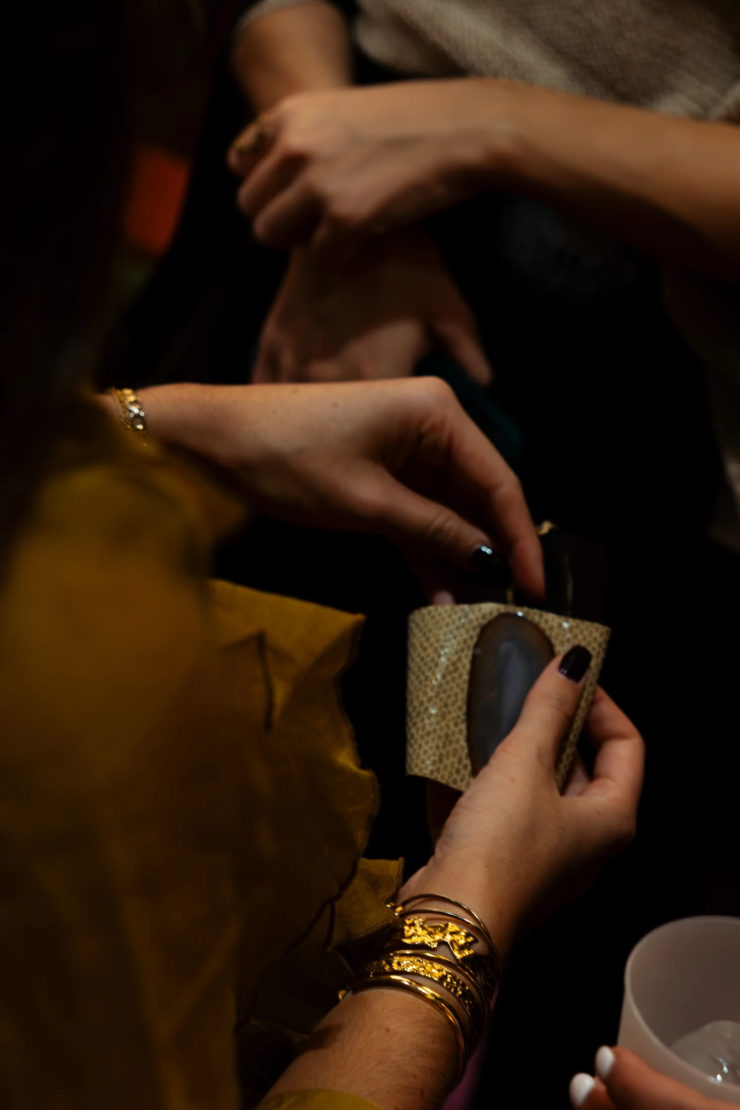 Hands examining a Balasoir cuff during the event, photographed by Ludovic Delot